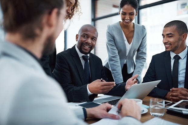 Business team in discussion around a laptop